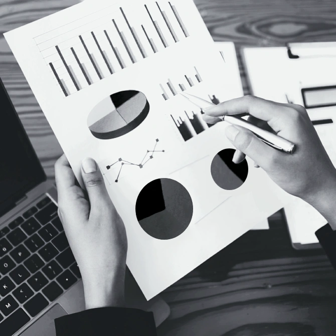 Female hands holding a sheet of paper with marketing analytics data printed on it.